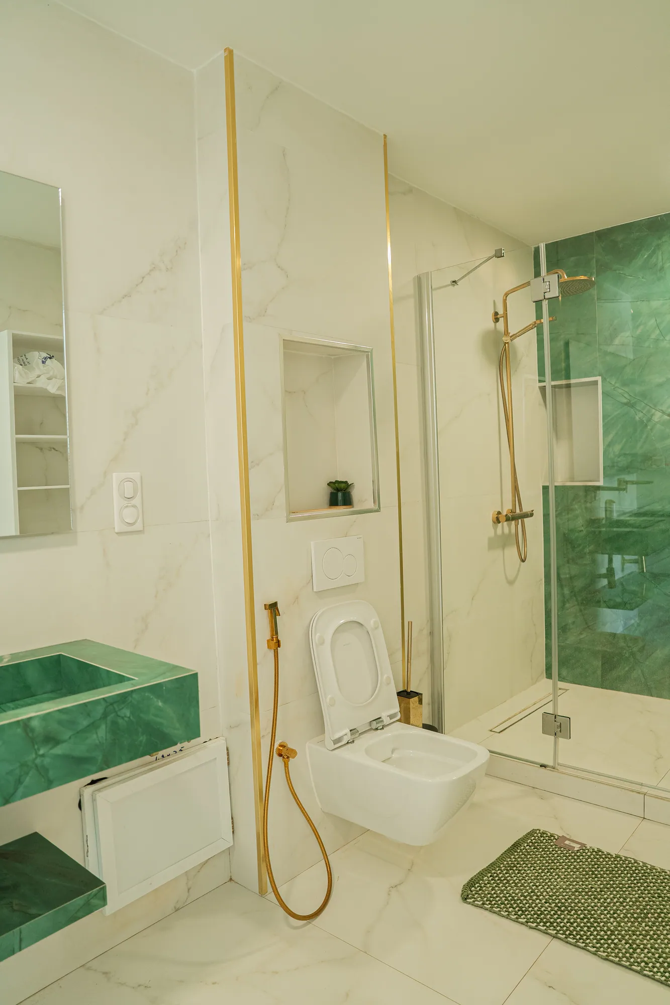 Salle de bain plaquée d'onyx vert, robinetterie dorée