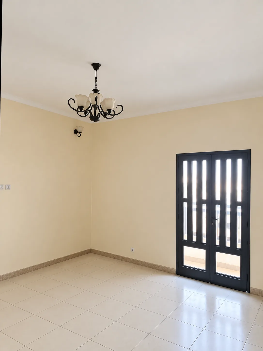 Salon nu, lustre et porte-fenêtre à châssis noir